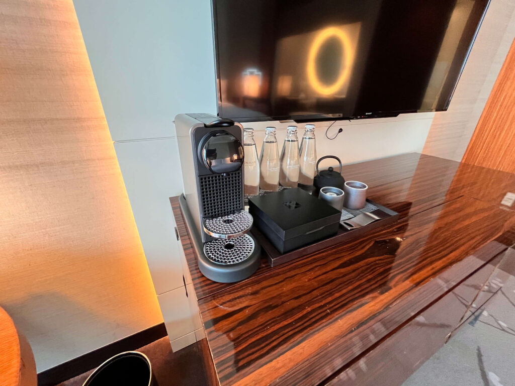 棚に置かれたコーヒメーカーやミネラルウォーターの写真